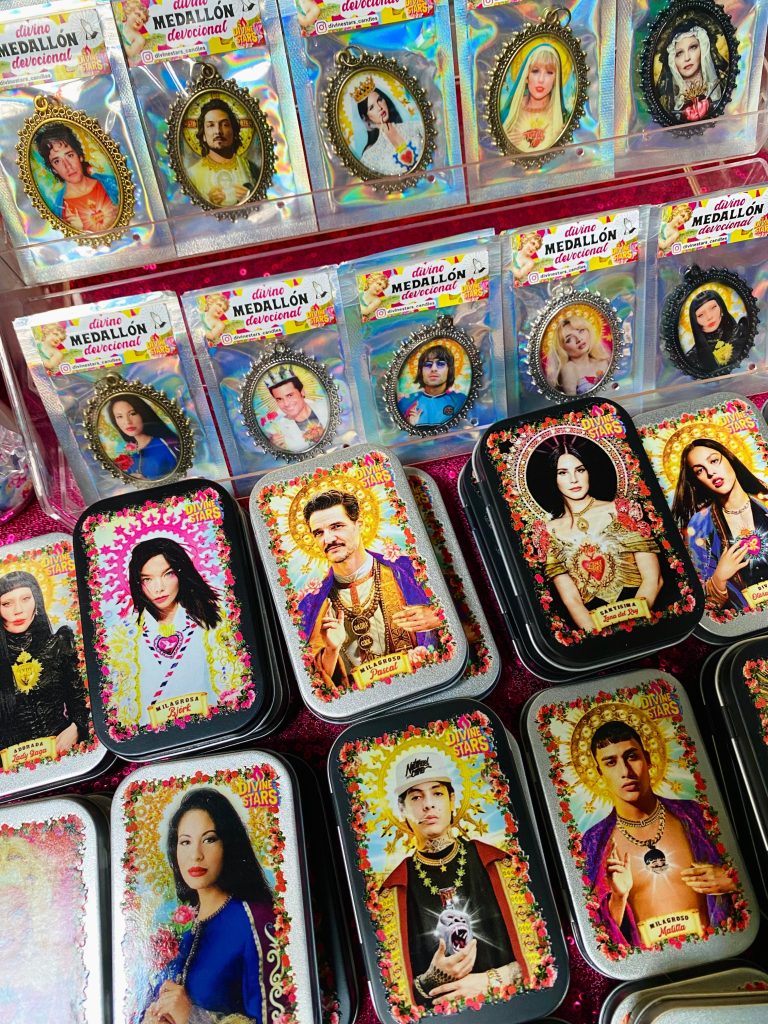 Divina caja metálica y medallón de Divine Stars con diseños de celebridades famosas en santos